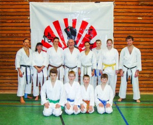Karatefreunde vom Delmenhorster TV beim Lehrgang im BKV vor dem Vereinslogo des Ausrichterdojos SKIP-Karate-Dojo Bremen e.V.